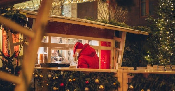 Mann betreut eine Weihnachtsbude im Winter